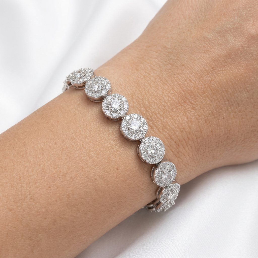 Close-up of sterling silver CZ cluster bracelet worn on a wrist against white satin